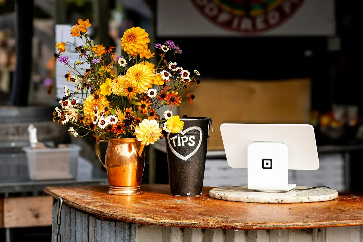 Ladentheke eines kleinen Geschäfts mit Blumenstrauß und Kartenterminal